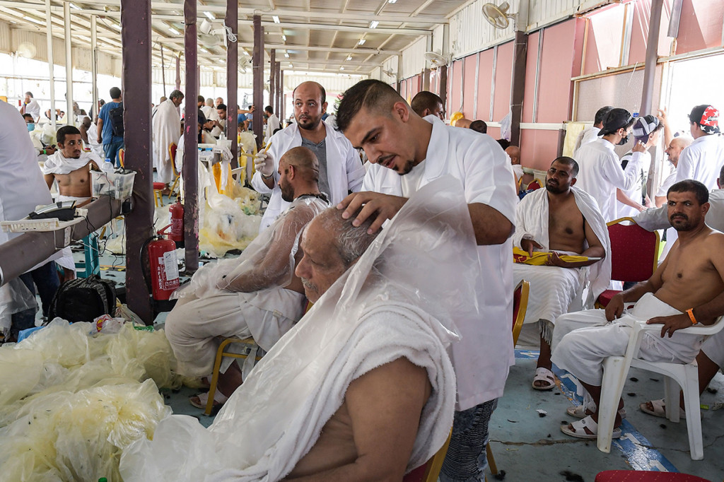 Jemaah haji mencukur rambut (tahalul) usai melempar jamrah di Jamarat.