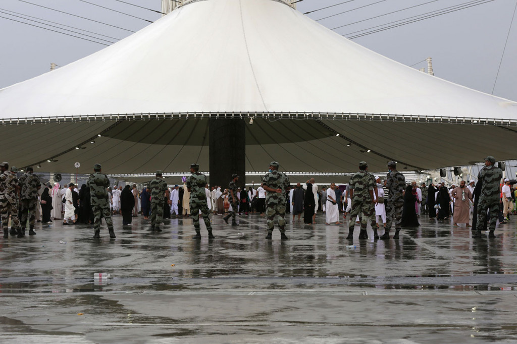 Pasukan keamanan Arab Saudi berjaga-jaga saat jemaah haji tiba di Mina untuk melakukan lempar jamrah di bawah guyuran hujan deras.