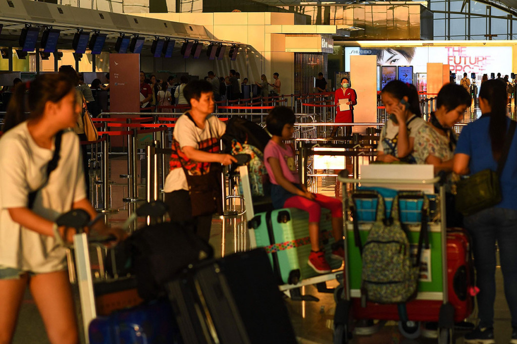 Para penumpang menunggu untuk chek-in usai Bandara Internasional Hong Kong kembali beroperasi, Selasa, 13 Agustus 2019.