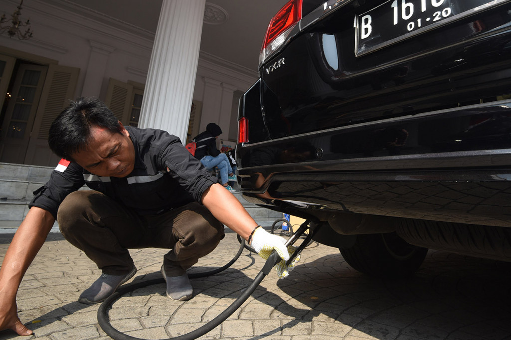 Seorang petugas Dinas Lingkungan Hidup Provinsi DKI Jakarta melakukan uji emisi kendaraan dinas saat peluncuran aplikasi e-Uji Emisi di Balai Kota DKI Jakarta.