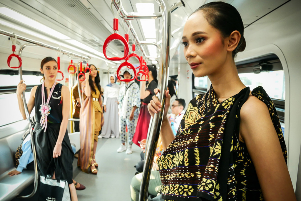 Model berpose saat peragaan busana Jakarta Fashion & Food Festival 2019 di dalam gerbong LRT rute Velodrome-Kelapa Gading, Jakarta.