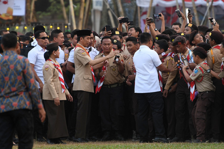 Presiden Joko Widodo (ketiga kiri) didampingi Ibu Negara Iriana Joko Widodo (kedua kiri) berfoto dengan peserta upacara seusai memimpin upacara peringatan Hari Ulang Tahun (HUT) ke-58 Pramuka di Bumi Perkemahan Cibubur, Jakarta.