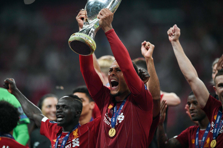 Pemain belakang Virgil van Dijk mengangkat tinggi-tinggi trofi Piala Super Eropa.