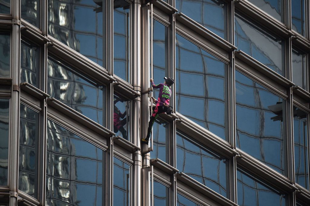Aksi 'Spiderman' asal Prancis, Alain Robert, saat memanjat gedung Cheung Kong Center di Hong Kong, Jumat, 16 Agustus 2019. Gedung pencakar langit tersebut memiliki 68 tingkat.