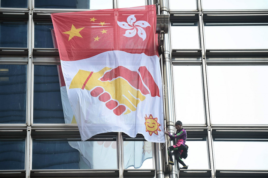 Di dalam spanduk terdapat gambar bendera Tiongkok di sebelah kiri dengan bendera Hong Kong di ujung sebelah kanan. Kemudian di bawahnya terdapat gambar tangan yang sedang bersalaman dengan dasar kain putih, yang menandakan perdamaian.   