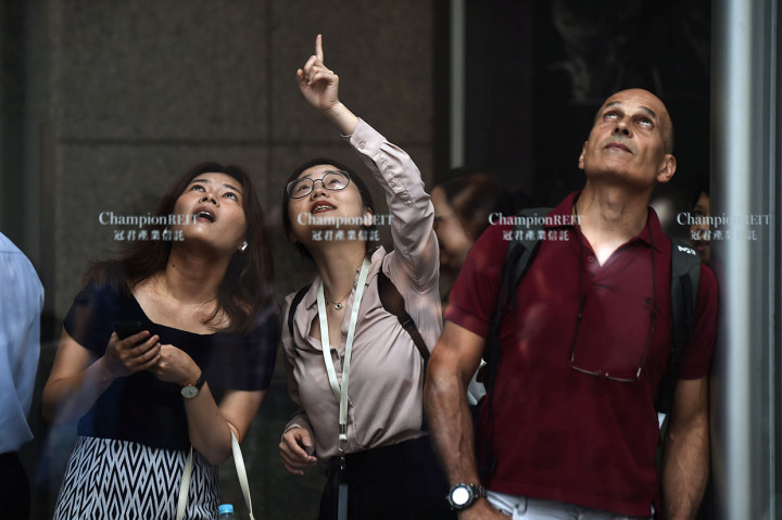 Warga mengabadikan aksi Alain Robert memanjat gedung 68 tingkat. Aksi Robert dilakukan saat pengerahan massa yang lebih besar diprediksikan terjadi pada akhir pekan. 