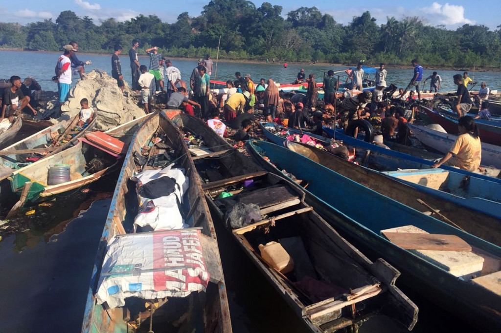 Puluhan warga membantu memindahkan barang masih dapat diselamatkan dari Kapal Motor (KM) Izhar yang terbakar di Perairan Bokori di Kecamatan Soropia, Konawe, Sulawesi Tenggara, Sabtu, 17 Agustus 2019.