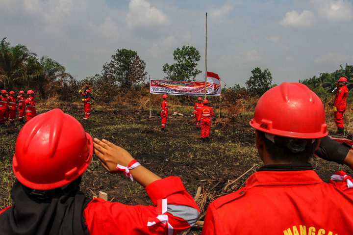 Personel Manggala Agni Daops Pekanbaru menggelar Upacara Bendera HUT ke-74 Kemerdekaan RI di dekat lokasi lahan gambut yang terbakar di Kabupaten Kampar, Riau, Sabtu, 17 Agustus  2019.
