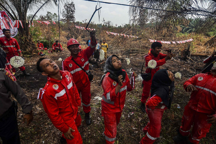 Setelah mengikuti lomba Agustusan, personel Manggala Agni pun kembali bertugas melaksanakan pemadaman dilahan gambut yang masih menyisakan bara api tersebut. AFP Photo/Wahyudi