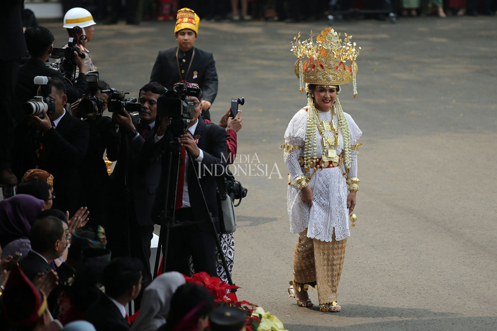 Nora Tristyana adalah istri Menhan Ryamizard Ryacudu dan juga anak dari Wakil Presiden 1993-1998 Try Sutrisno. Nora mengenakan pakaian adat Lampung berupa kebaya putih beserta tenun Lampung serta mahkota warna emas lengkap dengan asesoris emas sebagai gelang dan kalung yang menghiasi kebayanya.