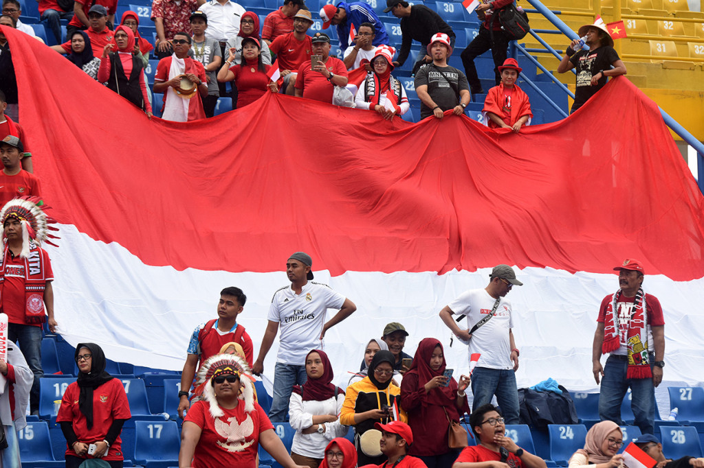 Sejumlah suporter Indonesia memberi dukungan kepada Timnas Indonesia U-18 saat bertanding melawan Malaysia pada semifinal Piala AFF U-18 di Stadion Go Dau di Provinsi Binh Duong, Vietnam.