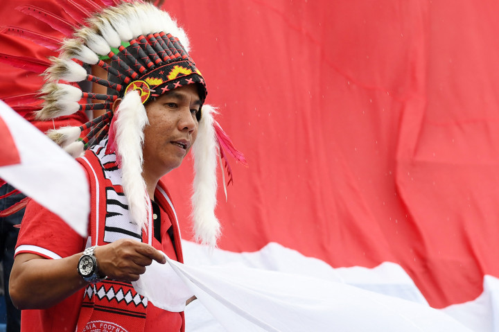 Suporter Indonesia mengibarkan bendera Merah Putih saat memberi dukungan kepada Timnas Indonesia U-18 yang bertanding melawan Malaysia pada semifinal Piala AFF U-18 di Stadion Go Dau di Provinsi Binh Duong, Vietnam.