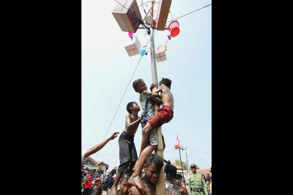 Anak-anak mengikuti perlombaan panjat pinang dalam rangka memeriahkan HUT ke-74 Kemerdekaan RI di sekitar lokasi terdampak bocornya minyak dari anjungan YYA milik Pertamina di lapangan desa Cemara Jaya, Karawang.