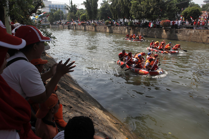 Sejumlah warga menyemangati peserta lomba balap perahu dayung di Sungai Ciliwung, Pasar Baru, Jakarta Pusat, Jakarta. 