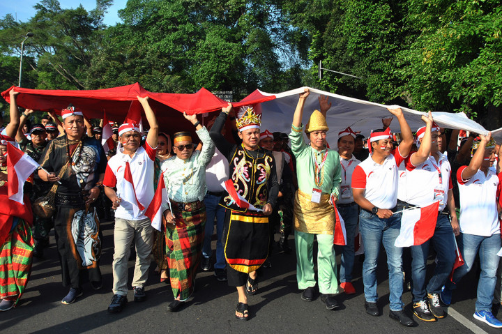 Wali Kota Bogor Bima Arya (kelima kiri) dan Wakil Wali Kota Dedie A Rachim (kempat kanan) bersama unsur muspida mengarak bendera merah putih di jalan Sudirman, Kota Bogor, Jawa Barat.