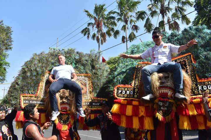 Direktur World Cycling Center UCI (persatuan balap sepeda Internasional) Frederic Magne (kiri) dan Ketua umum pengurus besar Ikatan Sport Sepeda Indonesia Raja Sabta Oktohari duduk di atas barongan (bagian dari seni Reog Ponorogo) sesaat sebelum pemberangkatan pembalap pada etape kedua Tour de Indonesia 2019 di Kota Madiun, Selasa, 20 Agustus 2019.