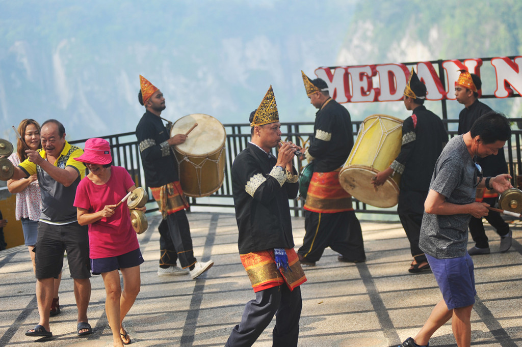 Penari dari Kelompok Seni Saayun Salangkah mengajak wisatawan asing asal Malaysia dan Singapura bermain alat musik tradisional