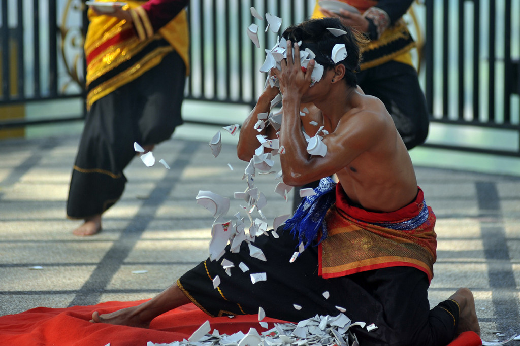 Penari dari Kelompok Seni Saayun Salangkah menampilkan tari piring dengan cuci muka menggunakan pecahan piring di Taman Panorama Ngarai Sianok, Bukittinggi, Sumatera Barat.
