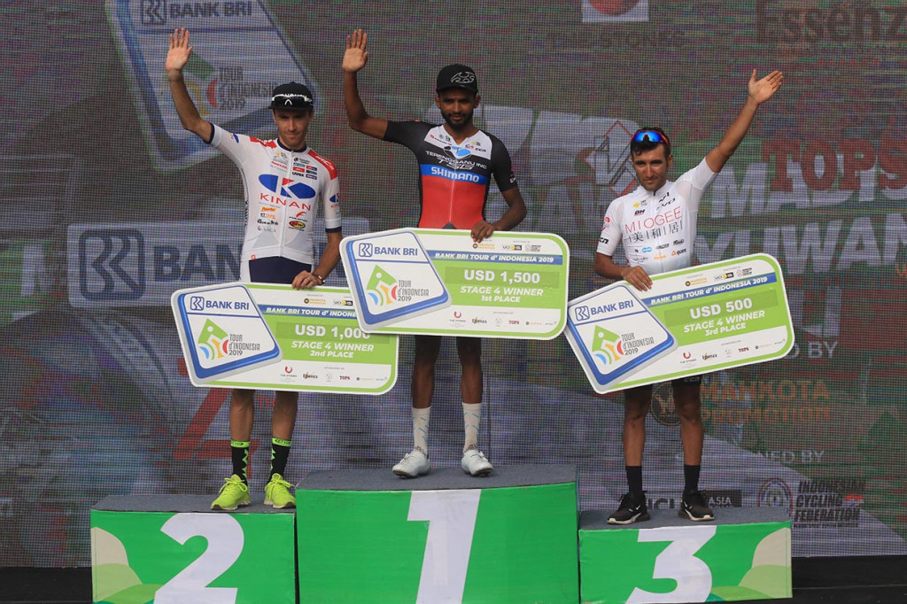 Pebalap dari Terengganu Cycling Team Eyob Metkel (kedua kiri), Lebas Thomas (kiri) dari Kinan Cycling team dan Kolah Douz Hagh menaiki podium usai finish pertama pada gelaran Tour de Indonesia di Paltuding, Gunung Ijen, Banyuwangi, Jawa Timur.