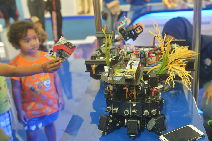 Seorang anak melihat robot penanam padi dalam Ritech Expo 2019 yaitu rangkaian peringatan Hari Kebangkitan Teknologi Nasional (Hakteknas) ke-24 di Denpasar, Bali.