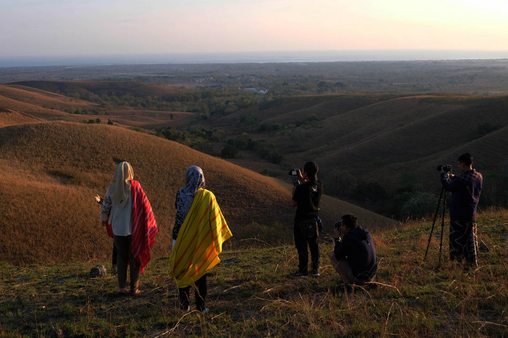 Wisatawan berfoto sambil menikmati keindahan matahari terbit di bukit Lendongara Desa Karunni, Loura, Kabupaten Sumba Barat Daya, Nusa Tenggara Timur.