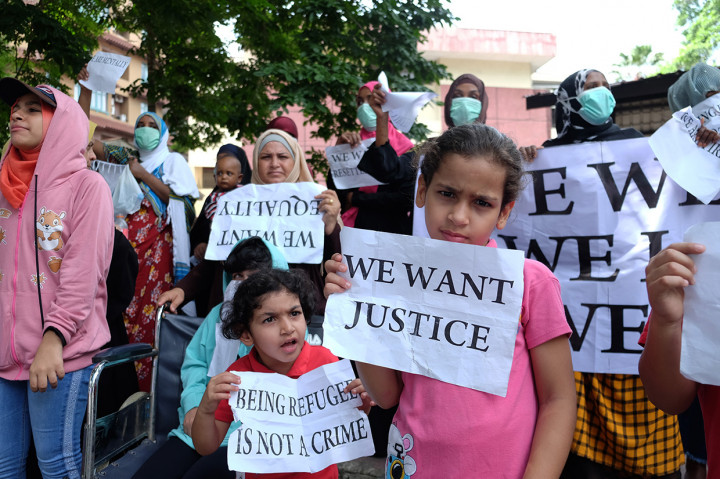 Puluhan imigran memegang poster ketika berunjuk rasa di depan kantor UNHCR, Medan, Sumatera Utara.
