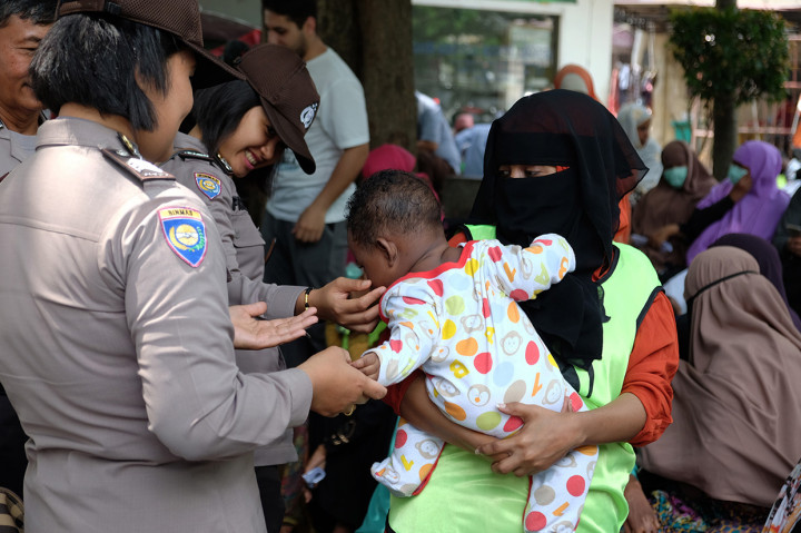 Seorang anak imigran asal Somalia bersama ibunya ikut berunjuk rasa di depan kantor UNHCR, Medan, Sumatera Utara.