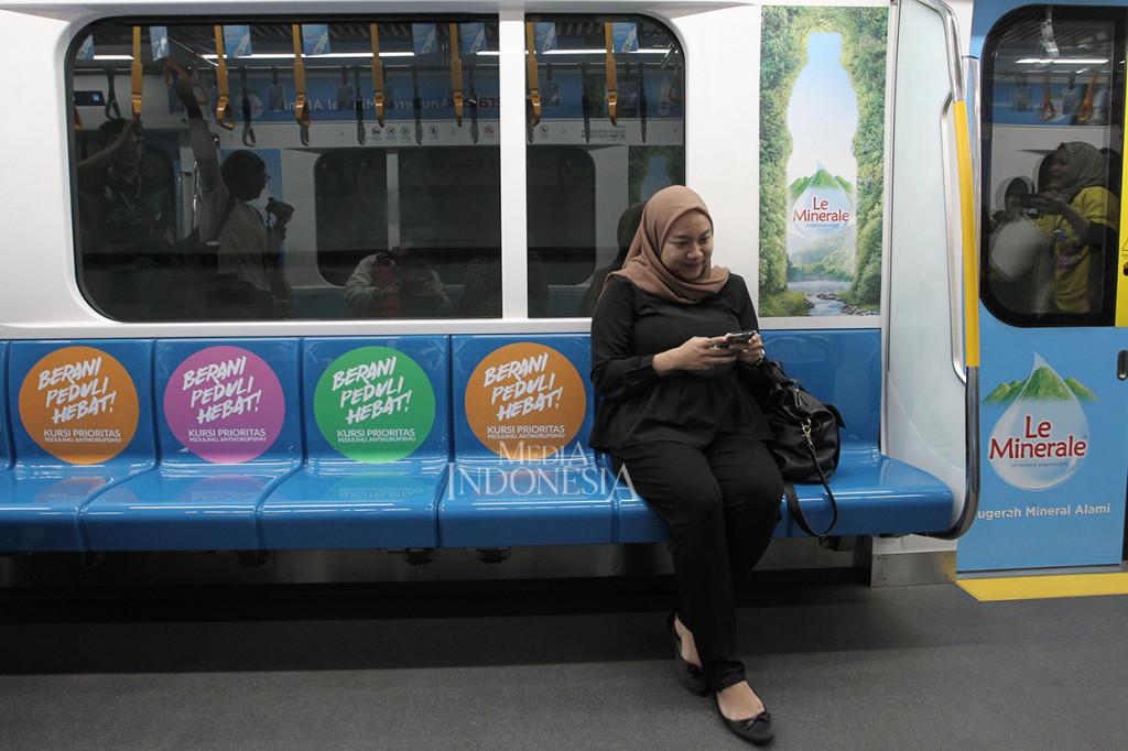 Penumpang duduk dikursi yang sudah ditempel stiker kampanye anti korupsi di gerbong kereta MRT saat pencanangan kampanye di Stasiun MRT Bundaran HI Jakarta.