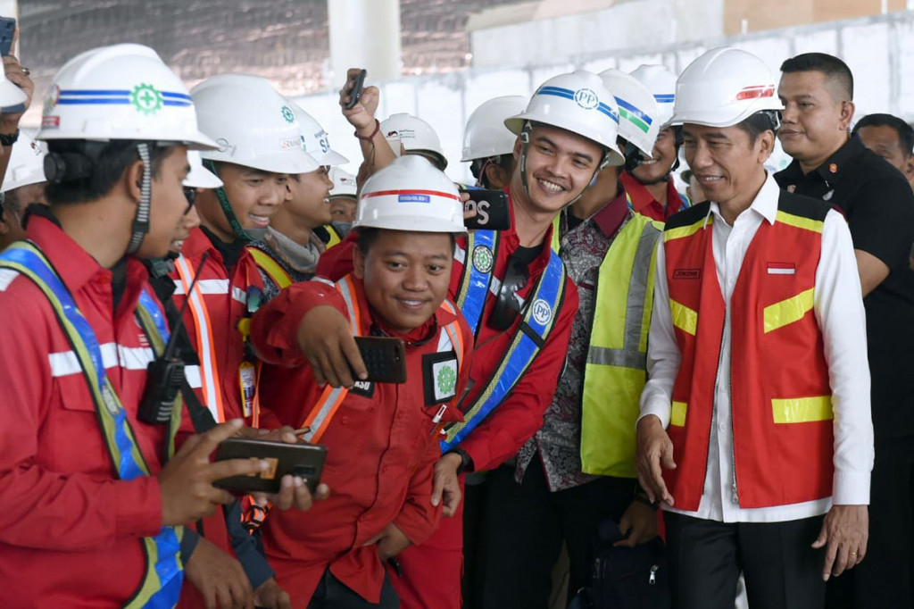 Pegawai bandara berebut foto bersama dengan Presiden Jokowi.