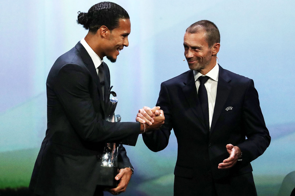 Bek Liverpool Virgil van Dijk mendapat ucapan selamat dari Presiden UEFA Aleksander Ceferin usai terpilih sebagai Pemain Terbaik Eropa 2018/2019, selama upacara pengundian grup Liga Champions di Monako, Kamis, 29 Agustus 2019 waktu setempat.