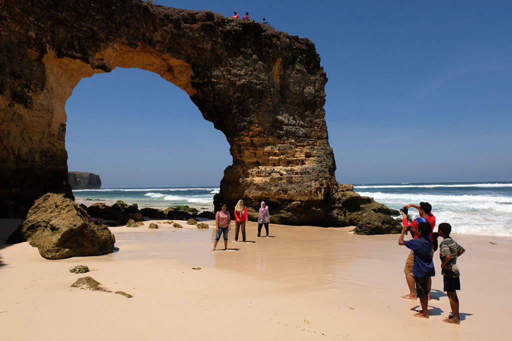 Wisatawan berfoto dengan latar belakang karang yang berlubang di Pantai Mbawana desa Panenggo Ede, Kodi Bangedo, Kabupaten Sumba Barat Daya, Nusa Tenggara Timur, Rabu, 28 Agustus 2019.
