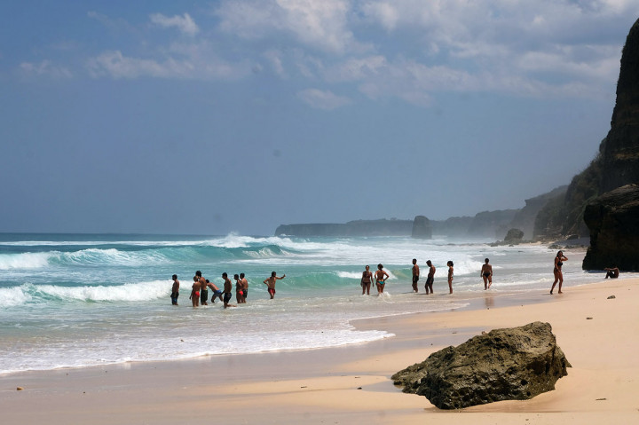 Sejumlah wisatawan lokal maupun mancanegara tengah menikmati ombak di Pantai Mbawana.