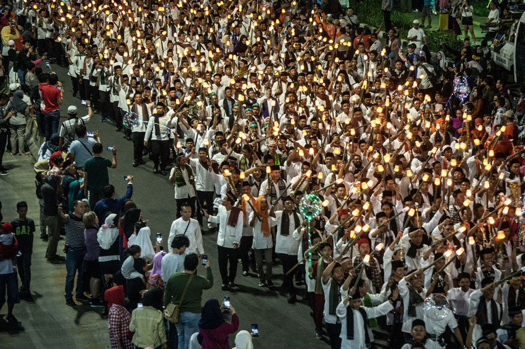 Sejumlah warga dengan membawa obor elektrik mengikuti Jakarta Muharram Festival di Jalan MH Thamrin, Jakarta. Antara Foto/Aprillio Akbar