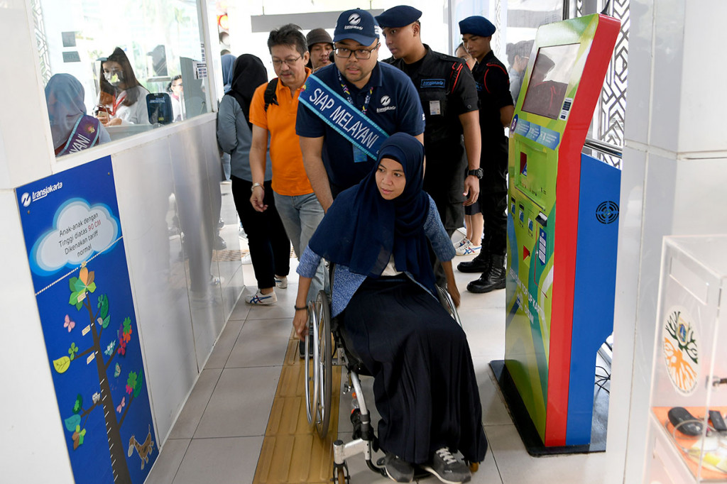 Direktur Teknik dan Fasilitas TransJakarta Yoga Adiwinarto mendorong calon penumpang penyandang disabilitas di Halte TransJakarta Bundaran Hotel Indonesia, Jakarta. 