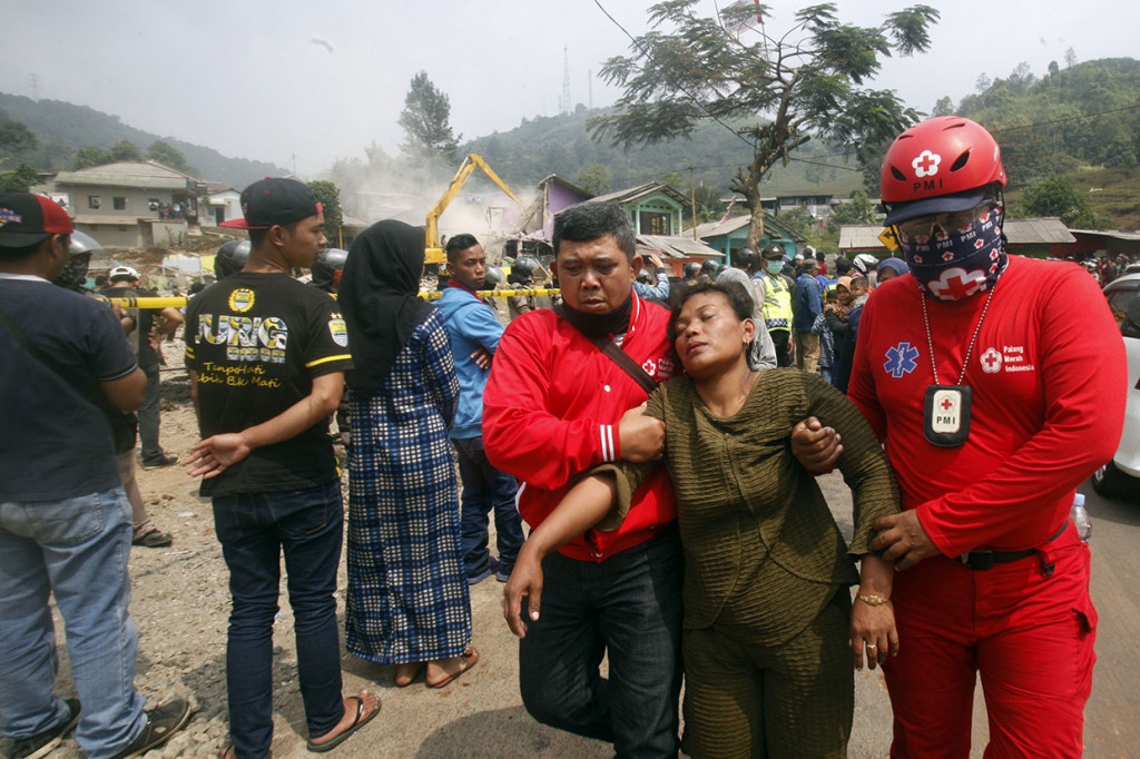 Petugas PMI mengevakuasi warga yang pingsan saat pembongkaran bangunan tidak berizin di Kampung Naringgul, Puncak, Bogor, Jawa Barat.