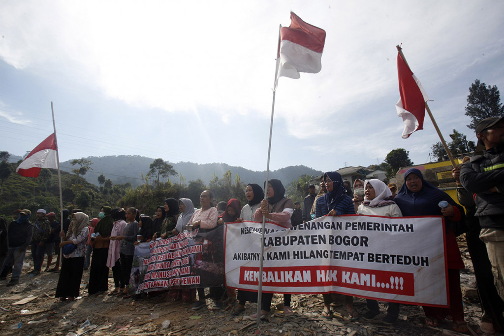 Mereka berusaha menghalau petugas dan alat berat yang hendak membongkar paksa puluhan unit rumah dengan cara membuat barikade sambil membentangkan spanduk penolakan.