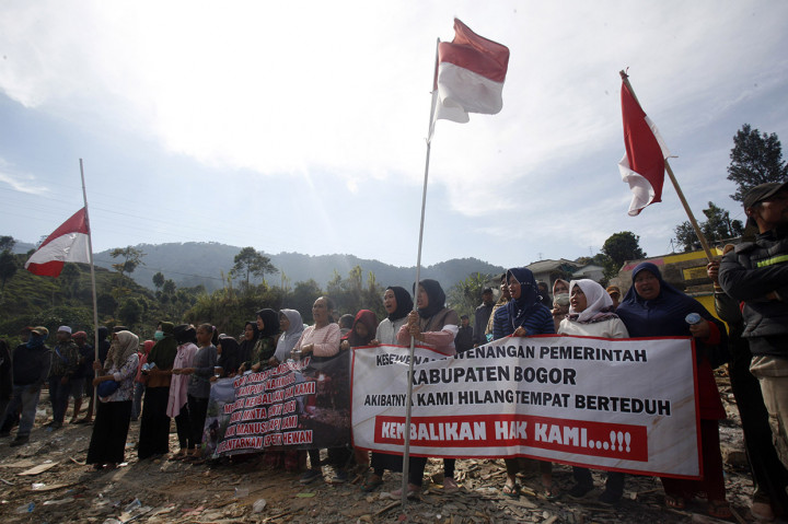 Mereka berusaha menghalau petugas dan alat berat yang hendak membongkar paksa puluhan unit rumah dengan cara membuat barikade sambil membentangkan spanduk penolakan.