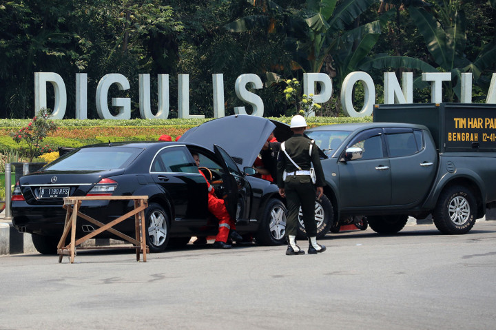 Prajurit TNI AD mengawal teknisi yang memperbaiki mesin mobil Kepresidenan Indonesia-1 yang sudah berganti plat di lokasi acara Presiden Joko Widodo membagikan sertifikat Tanah Objek Reforma Agraria (TORA) di Taman Digulis, Pontianak, Kalimantan Barat, Kamis, 5 September 2019. 