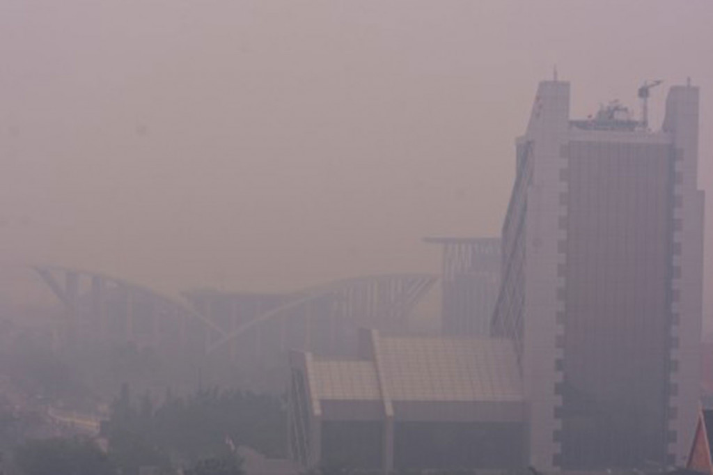 Gedung Perpustakaan Daerah Soeman HS (kiri) dan Menara Bank Riau-Kepri (kanan) tampak samar-samar saat kabut asap kebakaran hutan dan lahan (Karhutla) menyelimuti Kota Pekanbaru, Riau, Selasa, 10 September 2019. 