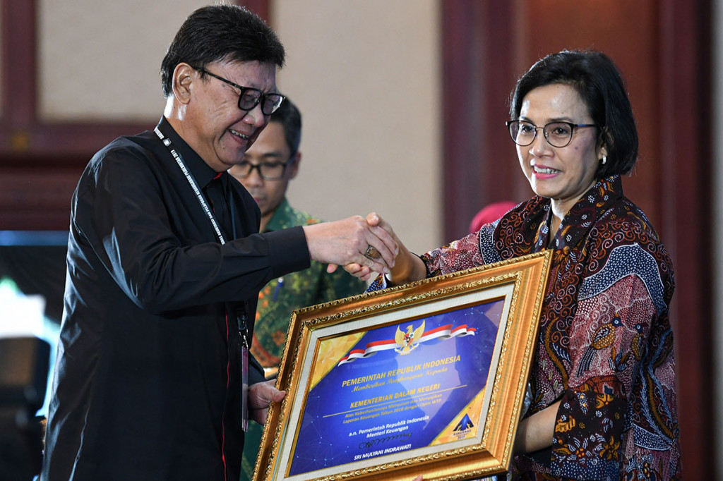 Menteri Keuangan Sri Mulyani menyerahkan penghargaan opini Wajar Tanpa Pengecualian (WTP) kepada Menteri Dalam Negeri Tjahjo Kumolo, dalam Rakernas Akuntansi dan Pelaporan Keuangan Pemerintah 2019 di Kantor Kementerian Keuangan, Jakarta, Kamis, 12 September 2019. 