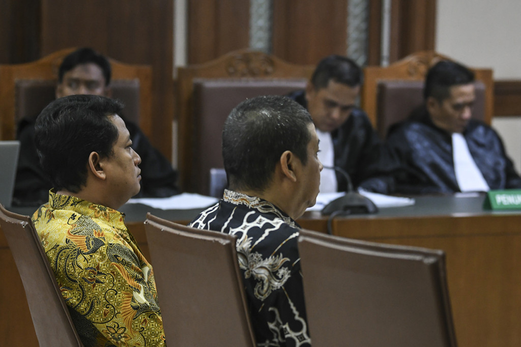 Mantan Pejabat Pembuat Komitmen (PPK) pada Kemenpora Adhi Purnomo (kanan) dan mantan Staf Kemenpora Eko Triyanto (kiri) mendengarakan pembacaan vonis yang dilakukan oleh majelis hakim di Pengadilan Tipikor, Jakarta.
