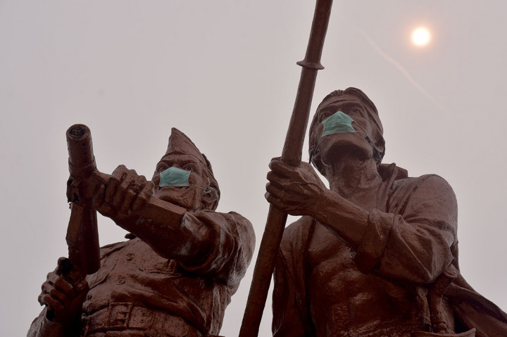 Dua patung di Monumen Perjuangan Rakyat Riau bermasker medis saat kabut asap pekat menyelimuti Kota Pekanbaru, Riau, Sabtu, 14 September 2019.