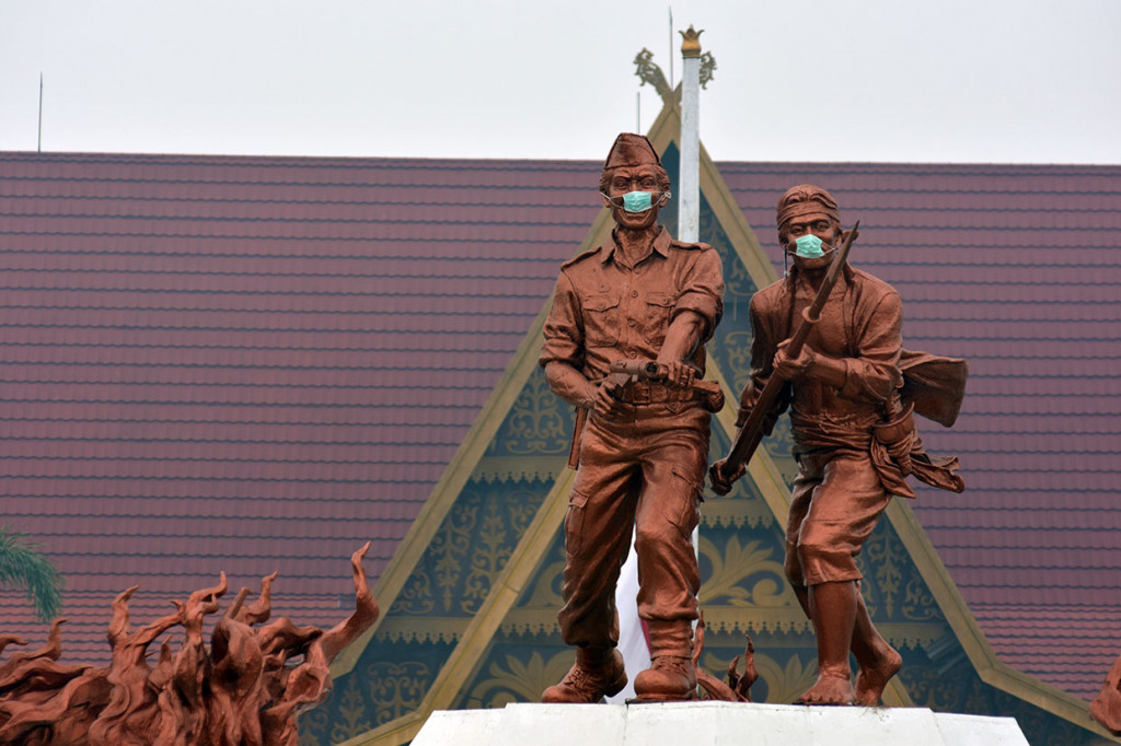 Masker warna hijau terlihat menutupi hidung dan mulut dua patung di Tugu Api yang lokasinya tepat di depan Gedung Daerah Riau di simpang empat Jalan Diponegoro dan Gajah Mada.    Dua patung tersebut berdiri di tengah monumen, menggambarkan sosok prajurit TNI memegang senjata dan rakyat menggunakan bambu runcing.