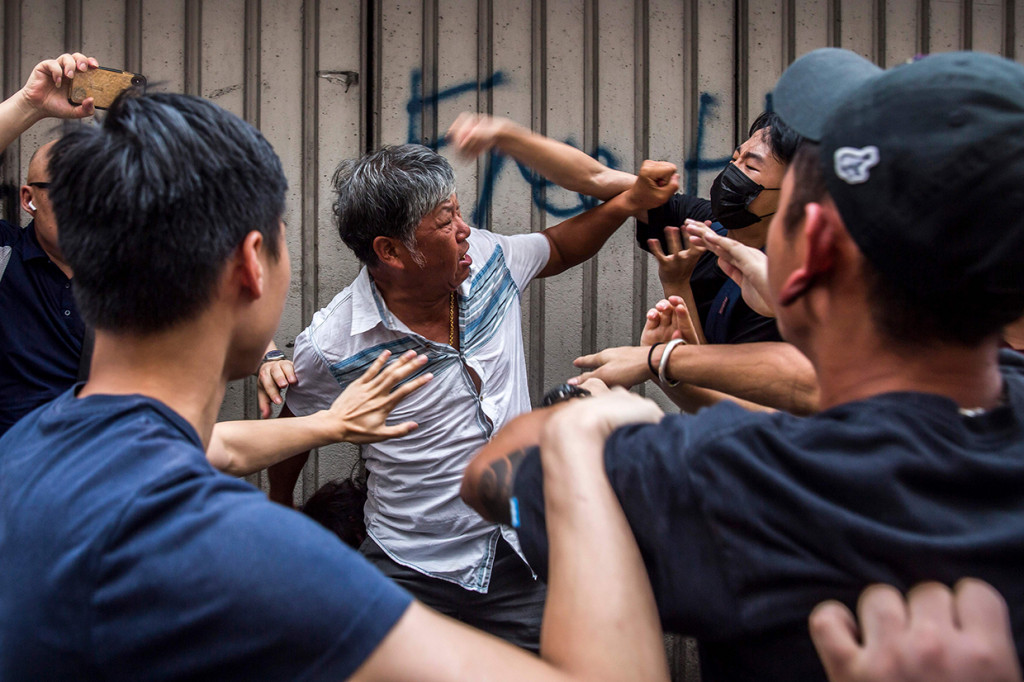 Demonstran pro-China berkelahi dengan demonstran antipemerintah di sebuah pusat perbelanjaan di Distrik Kowloon Bay, Hong Kong.

