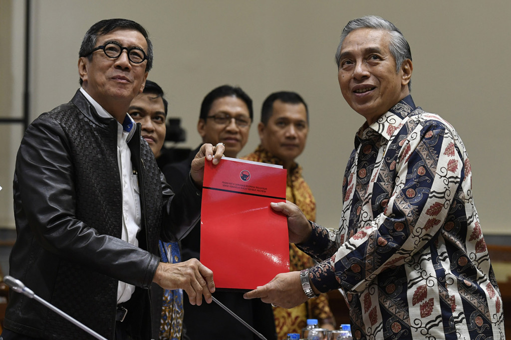 Menteri Hukum dan HAM Yasonna Laoly (kiri) menerima berkas tanggapan fraksisaat pembahasan Rancangan Kitab Undang-Undang Hukum Pidana (RKUHP) dengan Komisi III DPR di Kompleks Parlemen Senayan, Jakarta.