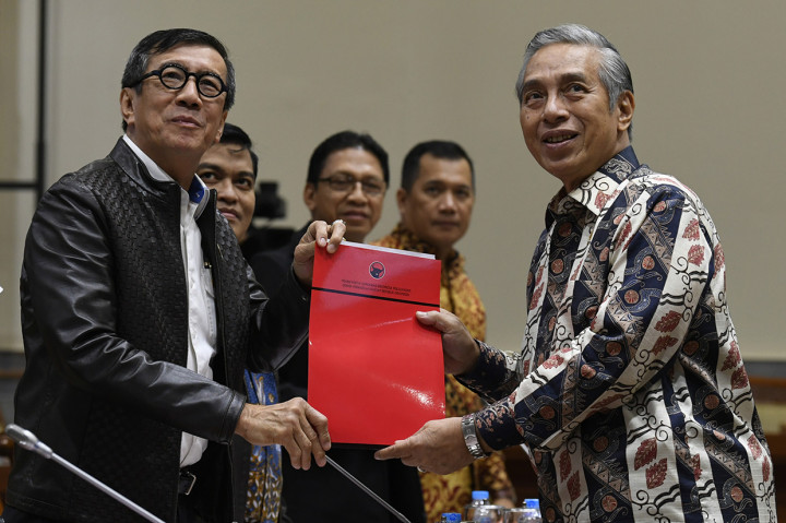 Menteri Hukum dan HAM Yasonna Laoly (kiri) menerima berkas tanggapan fraksisaat pembahasan Rancangan Kitab Undang-Undang Hukum Pidana (RKUHP) dengan Komisi III DPR di Kompleks Parlemen Senayan, Jakarta.