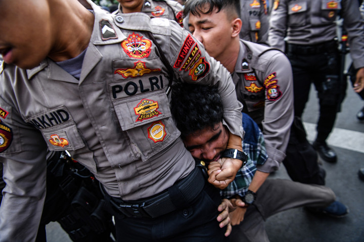 Polisi membawa anggota Himpunan Mahasiswa Islam (HMI) saat terjadi bentrokan dalam unjuk rasa di depan Kantor KPK, Jakarta.