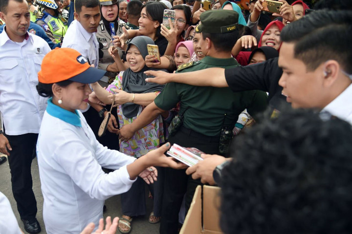 Selain mencanangkan Aksi Gerakan Indonesia Bersih, Iriana menyempatkan diri untuk membagi-bagikan buku tulis kepada masyarakat sekitar yang telah menunggunya di tepian Jalan Raya Cilebut. Setpres Biro Pers/Lucas