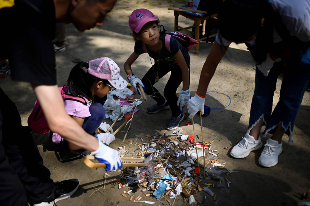 Relawan memilah sampah setelah dikumpulkan di sebuah taman di Beijing, Tiongkok, Sabtu. AFP Photo/Wang Zhao