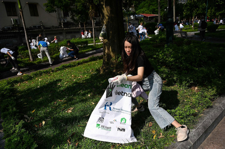 Puluhan relawan membersihkan sampah yang bertebaran di sebuah taman di dekat West Lake, Hanoi, Vietnam, Sabtu. AFP Photo/Manan Vatsyayana